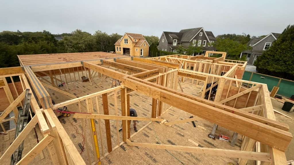 Precision wood framing of a new home addition, aerial view of engineered structure
