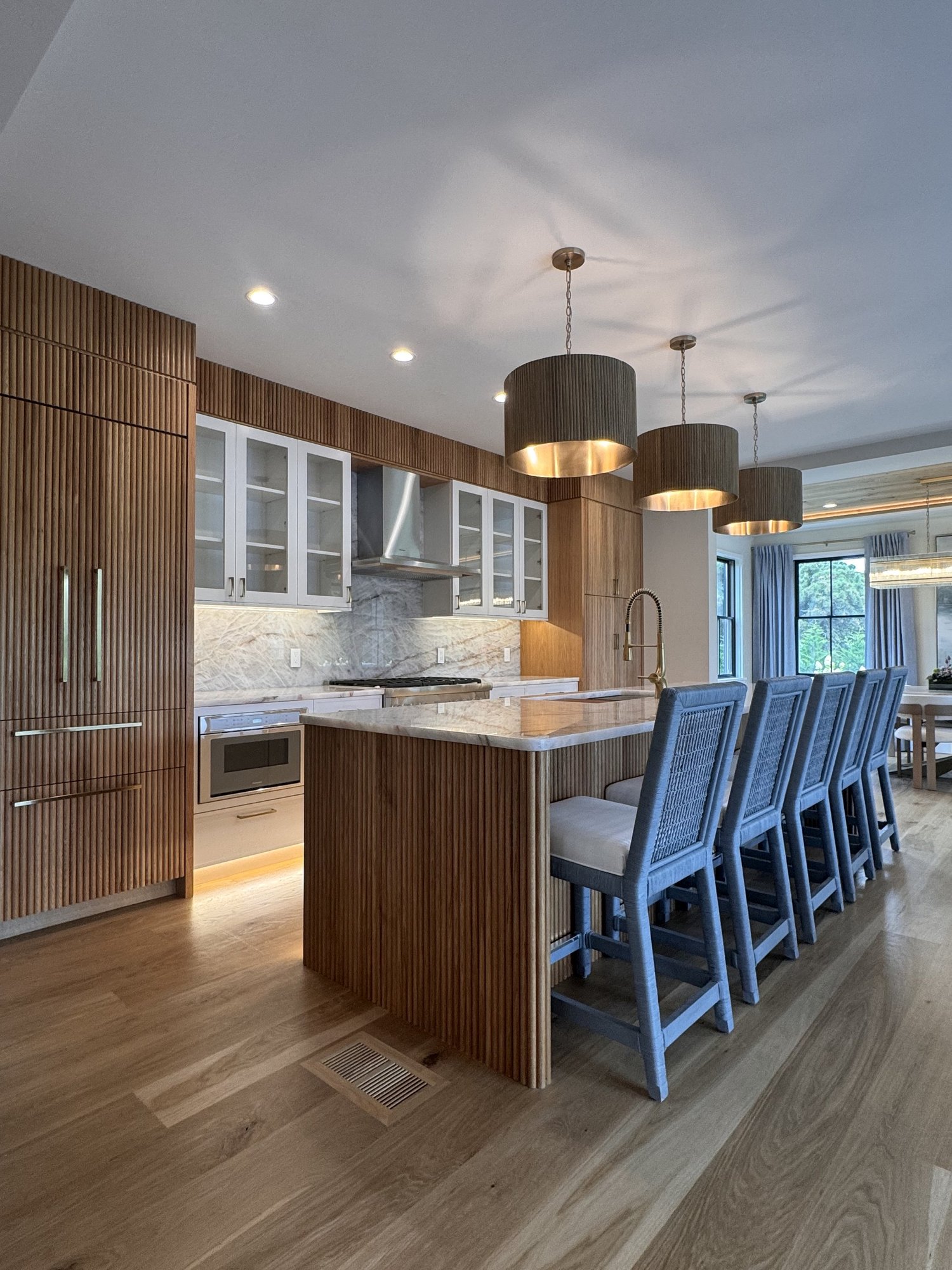 Custom kitchen remodel with fluted white oak cabinetry and marble island by HawkPro Builders