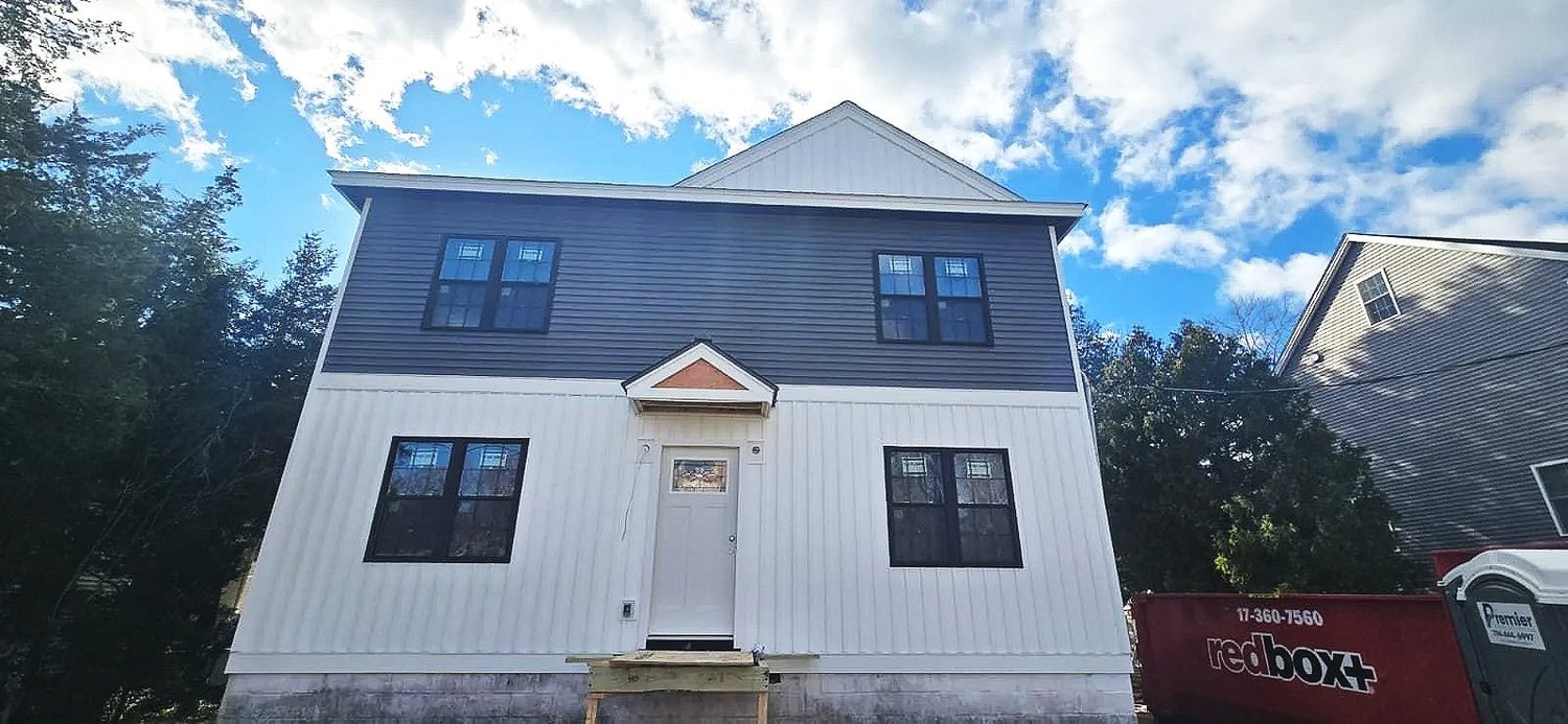 Two-story home with new two-tone vertical and lap siding installed by HawkPro